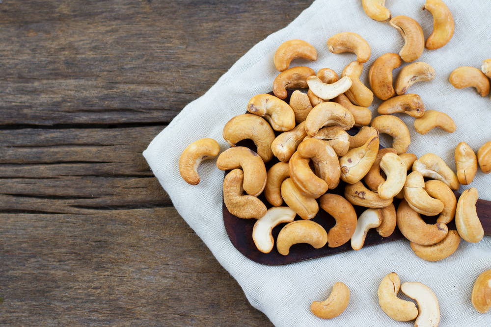 cashewnötter på ett fat på ett träbord